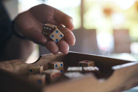Closeup Image Of Hand Holding And Rolling Wooden Dices