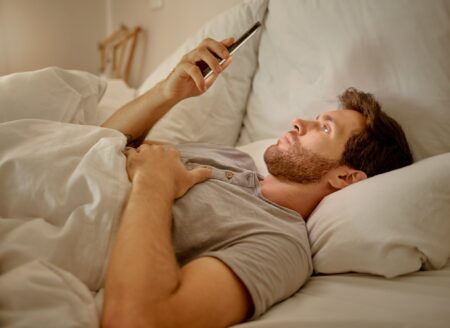 Man In Bed At Night With Phone Live Streaming On Mobile App, Social Media Content On The Internet